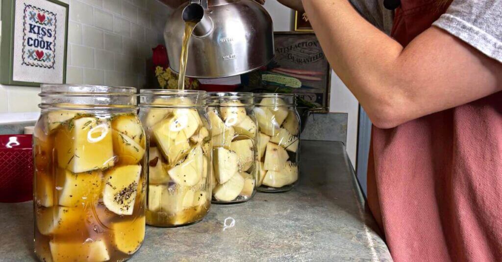 Jars of herbed potatoes on the counter ready to be canned.