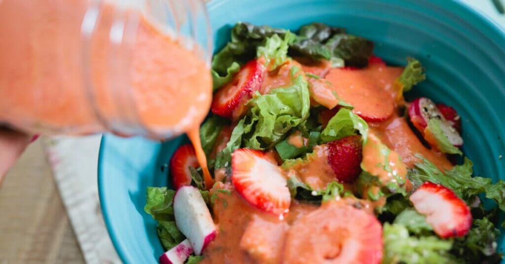 Strawberry vinaigrette poured over a fresh salad
